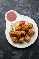 rava Bhajj or bhajiya also known as suji Pakoda or semolina Pakora, served with tomato ketchup. selective focus