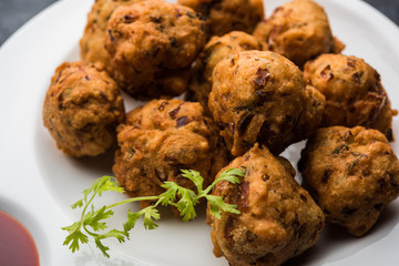 rava Bhajj or bhajiya also known as suji Pakoda or semolina Pakora, served with tomato ketchup. selective focus