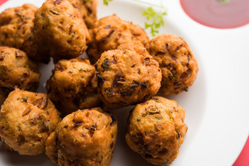 rava Bhajj or bhajiya also known as suji Pakoda or semolina Pakora, served with tomato ketchup. selective focus