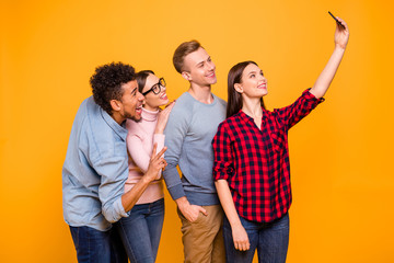 Obraz premium Portrait of nice-looking attractive lovely charming funky cheerful cheery company buddy fellow chatting using device gadget taking making selfie isolated over bright vivid shine yellow background