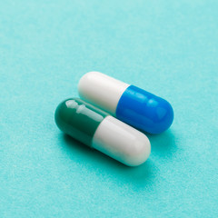 colour tablets and pills on blue background .