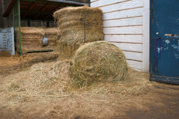 Hay rolls stacked in front of the farm entrance