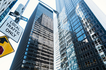 Obraz premium Glass high skyscrapers and road sign on street