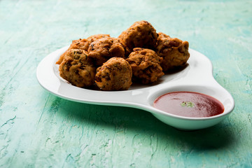 rava Bhajj or bhajiya also known as suji Pakoda or semolina Pakora, served with tomato ketchup. selective focus