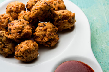 rava Bhajj or bhajiya also known as suji Pakoda or semolina Pakora, served with tomato ketchup. selective focus