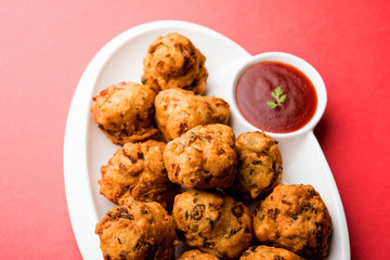 rava Bhajj or bhajiya also known as suji Pakoda or semolina Pakora, served with tomato ketchup. selective focus