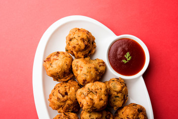 rava Bhajj or bhajiya also known as suji Pakoda or semolina Pakora, served with tomato ketchup. selective focus