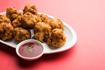 rava Bhajj or bhajiya also known as suji Pakoda or semolina Pakora, served with tomato ketchup. selective focus