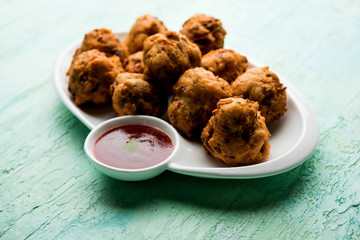 rava Bhajj or bhajiya also known as suji Pakoda or semolina Pakora, served with tomato ketchup. selective focus