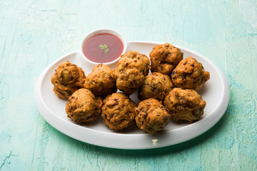 rava Bhajj or bhajiya also known as suji Pakoda or semolina Pakora, served with tomato ketchup. selective focus