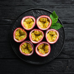 Passion fruits on a wooden background. Tropical Fruits. Top view. Free space for text.