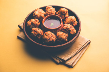 rava Bhajj or bhajiya also known as suji Pakoda or semolina Pakora, served with tomato ketchup. selective focus