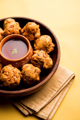 rava Bhajj or bhajiya also known as suji Pakoda or semolina Pakora, served with tomato ketchup. selective focus
