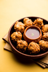 rava Bhajj or bhajiya also known as suji Pakoda or semolina Pakora, served with tomato ketchup. selective focus