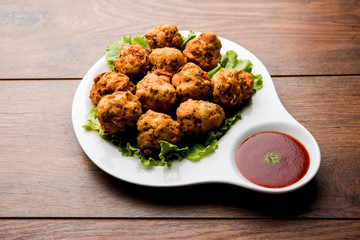 rava Bhajj or bhajiya also known as suji Pakoda or semolina Pakora, served with tomato ketchup. selective focus