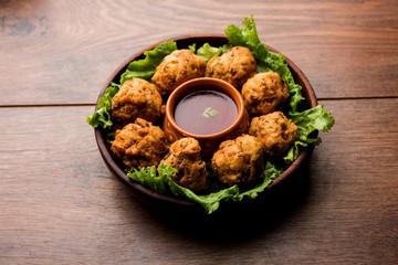 rava Bhajj or bhajiya also known as suji Pakoda or semolina Pakora, served with tomato ketchup. selective focus