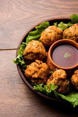 rava Bhajj or bhajiya also known as suji Pakoda or semolina Pakora, served with tomato ketchup. selective focus