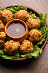 rava Bhajj or bhajiya also known as suji Pakoda or semolina Pakora, served with tomato ketchup. selective focus