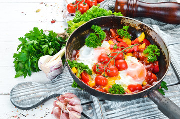 Shakshuka Eggs with tomatoes and vegetables in a frying pan. Breakfast. Top view. Free space for your text.