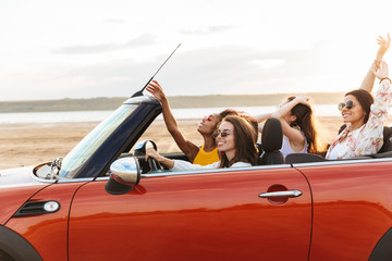 Pretty happy smiling cheery young pretty women friends driving the car.