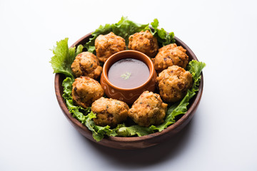 rava Bhajj or bhajiya also known as suji Pakoda or semolina Pakora, served with tomato ketchup. selective focus