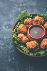 rava Bhajj or bhajiya also known as suji Pakoda or semolina Pakora, served with tomato ketchup. selective focus