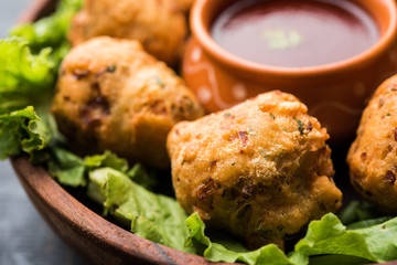 rava Bhajj or bhajiya also known as suji Pakoda or semolina Pakora, served with tomato ketchup. selective focus