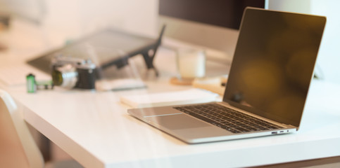 Laptop on modern white table with abstract blurred background