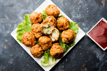 rava Bhajj or bhajiya also known as suji Pakoda or semolina Pakora, served with tomato ketchup. selective focus