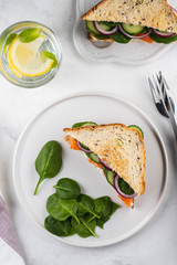 Sandwiches with cream cheese, salmon and spinach on a white backround.
