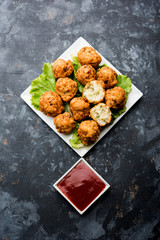 rava Bhajj or bhajiya also known as suji Pakoda or semolina Pakora, served with tomato ketchup. selective focus