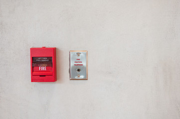 Fototapeta na wymiar Red fire alarm trigger on the wall with outlet for fire fighter telephone.