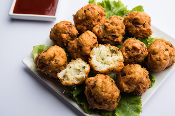 rava Bhajj or bhajiya also known as suji Pakoda or semolina Pakora, served with tomato ketchup. selective focus