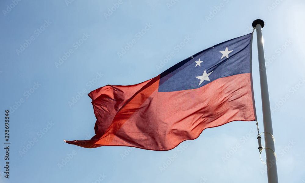 Poster samoa flag waving against clear blue sky