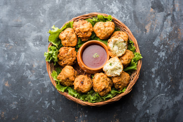 rava Bhajj or bhajiya also known as suji Pakoda or semolina Pakora, served with tomato ketchup. selective focus