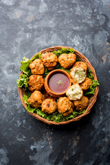 rava Bhajj or bhajiya also known as suji Pakoda or semolina Pakora, served with tomato ketchup. selective focus