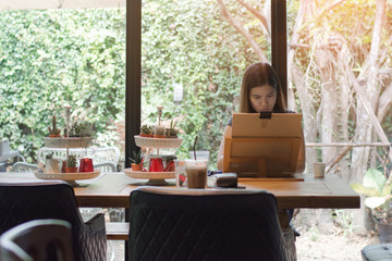 Beautiful woman embodying her ideas on paper with help of paintbrush and watercolors, interior of...