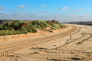Naklejka premium Construction of a new road. The marked space is covered with sand and rammed