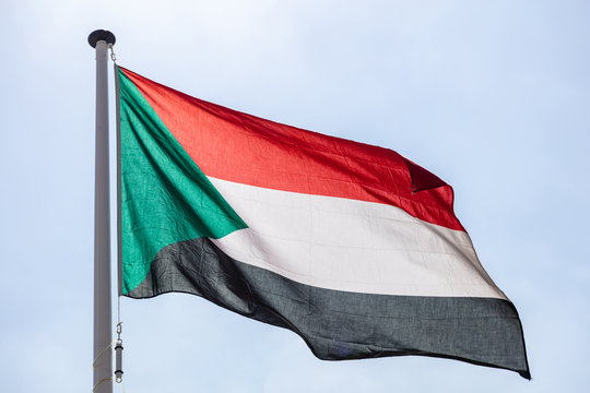 Sudan flag waving against clear blue sky