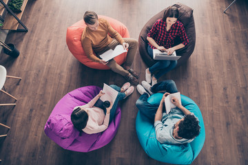 Top above high angle view of busy stylish guys junior managers sitting on bag chair preparing...