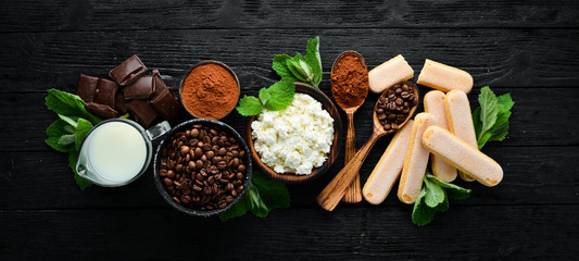 Ingredients for Tiramisu Dessert. Top view. On a black wooden table. Free space for your text.