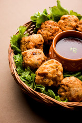 rava Bhajj or bhajiya also known as suji Pakoda or semolina Pakora, served with tomato ketchup. selective focus