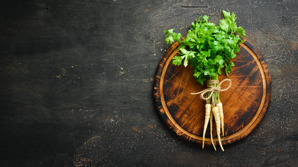 Obraz na płótnie Canvas Root parsley on a wooden background. Top view. Free space for your text.
