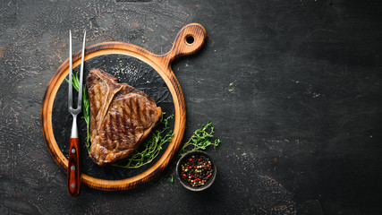 Grilled T-Bone Steak on the old table. Top view. Free space for text.
