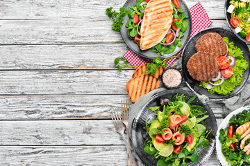 A set of delicious restaurant dishes on a white wooden background Top view. Free space for your text. Flat lay