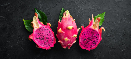 Red Pitahaya on a black background. Fruit Dragon. Tropical Fruits. Top view. Free space for text.