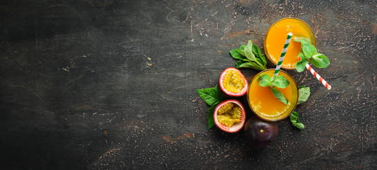 Passion fruits juice and fruits on a wooden background. Tropical Fruits.