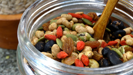Colorful and nutritious healthy foods image with raisin, fried beans, lycium chinense, and pumpkin seed. A new dietary concept.