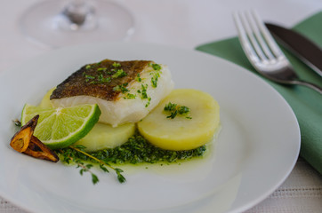Baked fillet fish  with garnish and  sauce in the restaurant table .