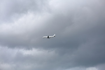 A large civil aviation aircraft flies in the sky in cloudy weather
